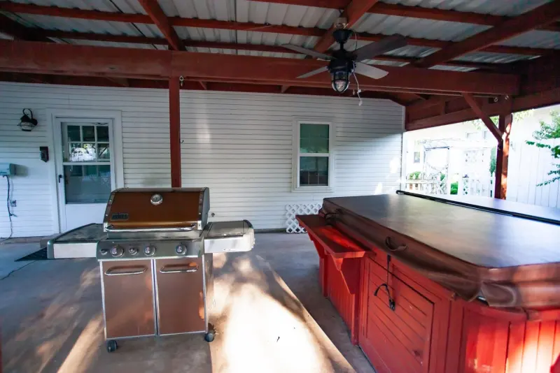 Covered patio with the hot tub and a gas grill