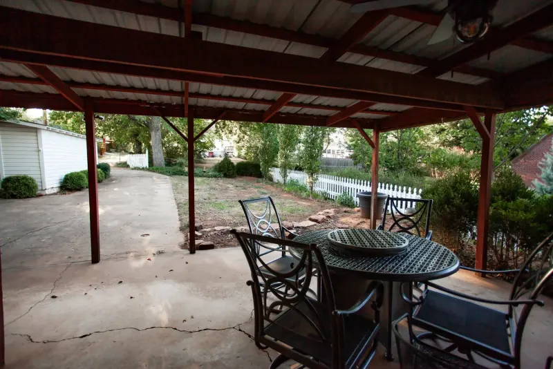 Tables and chairs on the covered patio, looking out to the yard